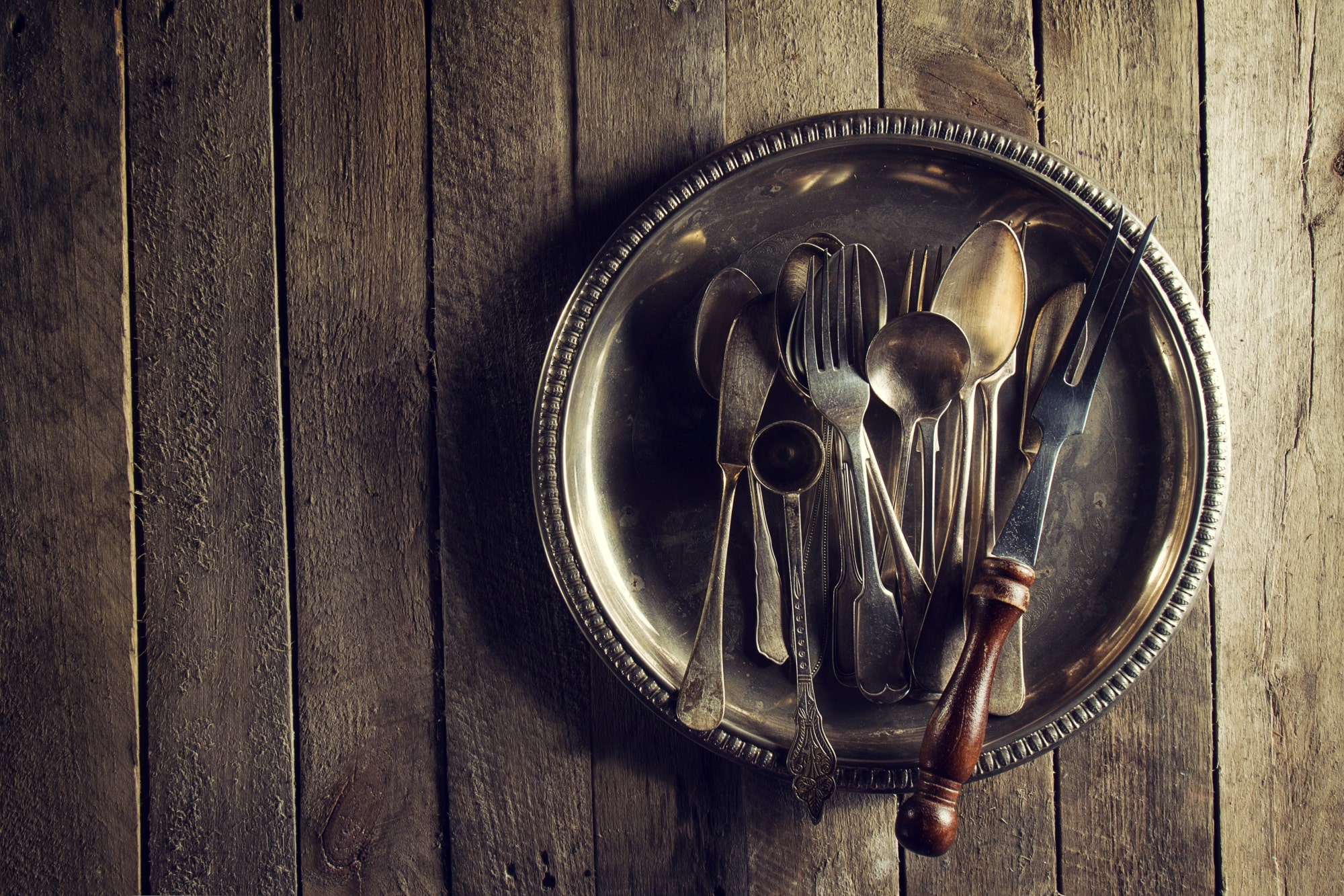 Au-napoléon-dor-expertise-achat-objets-precieux-Langon-Gradignan-vintage-old-rustic-kitchen-utensils-fourchettes-cuilleres-couteaux-vieille-table-bois-nourriture-vintage-rustic-concept-vue-dessus
